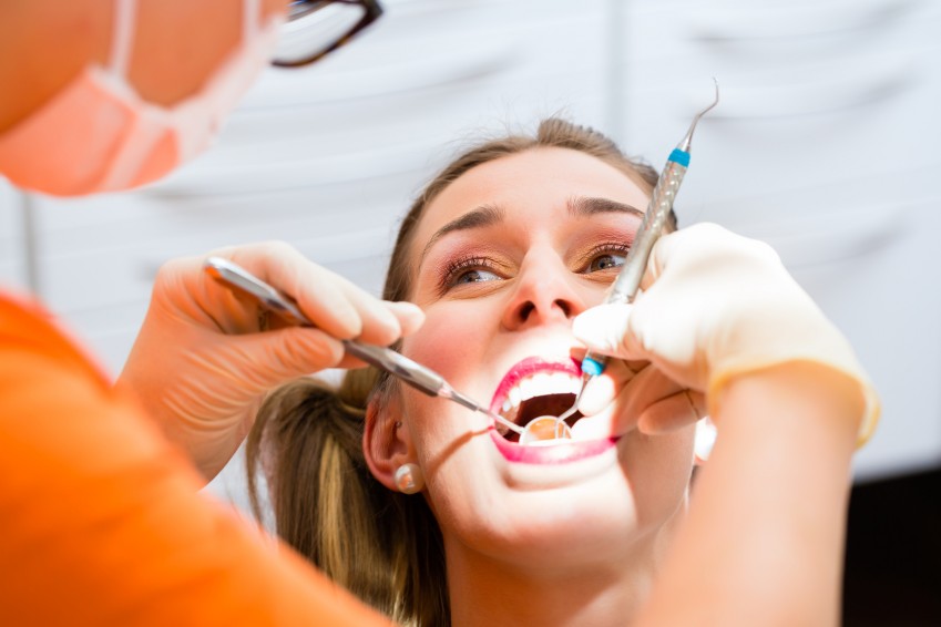 Patient having deep dental tooth cleaning at dentist